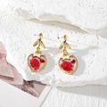 Detailed macro view of heart-shaped resin earrings with real dried red flowers - Half Red Flower