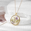 Détail d'un pendentif en résine dorée avec des fleurs séchées colorées et des feuilles - Gypso Blanc Jaune Et Fleur Blanche