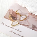 Close-up of cloud-shaped resin drop earrings with golden moon studs and floral details - White Cloud