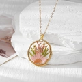 Vue détaillée du pendentif en résine transparente avec vraie marguerite et cadre doré ondulé - Marguerite Rose Et Gypso Rose