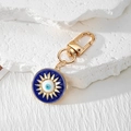 Goldener Evil Eye Schlüsselanhänger mit blauem Emaille-Inlay auf strukturiertem Stein - Gold Sonne Rundes Auge