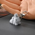 Gros plan d'un adorable porte-clés lapin gris floqué avec un fermoir en métal argenté - Lapin Gris Allongé