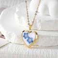 Detailed macro shot of heart-shaped gold locket with blue dried flowers in resin - Two Small Blue Flowers (Stainless Steel Chain)
