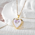 Detailed view of a golden heart pendant with purple dried flowers on a white stone base - Purple Flower (Stainless Steel Chain)