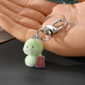 Dettaglio portachiavi a forma di serpente verde in morbido peluche con ciondolo rosso fortunato - Serpente Verde Portafortuna