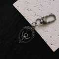 Gothic silver spider oval pendant keychain with vintage Victorian floral engraving detail - Black Spider Keychain