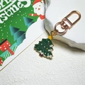 Gros plan d'un porte-clés sapin de Noël en émail avec un fermoir en métal or rose - Sapin de Noël