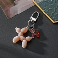 Detail of flocked balloon dog keychain and glitter resin pendant with silver clasp - Luminous Coffee