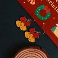 Gros plan détaillé de boucles d'oreilles cloches de Noël avec des nœuds rouges - Cloche