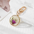 Handmade keychain with purple and white dried daisy flowers in clear round resin pendant - Purple Daisy White Gypsophila