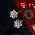 Detailed view of white enamel snowflake drop earrings with golden alloy hooks - Snowflake