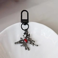 Porte-clés papillon gothique noir fusil avec pierre précieuse rouge centrale - Papillon