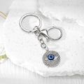 Macro view of blue Evil Eye keychain with sparkling rhinestones on textured stone surface - Silver Hollow Round Eye (2)