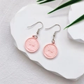 Detailansicht der rosa Makronen-Münzohrringe mit geprägtem Porträt von Königin Elisabeth II. - Rosa