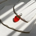 Detailed close-up of a resin strawberry keychain with green leaf and silver lobster clasp - Strawberry
