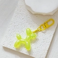 Macro detail of a translucent yellow balloon dog keychain with a matching metal lobster clasp - Holographic Yellow