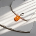 Close-up of a miniature orange resin sushi charm with silver metal lobster clasp - Orange