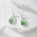 Vue détaillée de boucles d'oreilles goutte en résine avec vraies fleurs séchées vertes - Gypsophile Vert