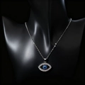 Close-up of Turkish Evil Eye pendant with clear rhinestones on black mannequin - Lace Silver Hollow Slanted Eye