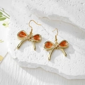 Detailed view of handmade bow earrings with orange dried flowers and golden resin frames - Stainless Steel Earring Hook / Orange Flower Large Bow