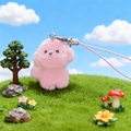 Cute pink plush poodle keychain with silver metal clasp on a green lawn background - Pink Puppy Phone Strap