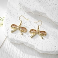 Close-up of bow earrings with real dried flowers embedded in clear resin and gold hooks - Stainless Steel Earring Hook / White Flower Pink Gypsophila Small Bow