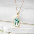Macro shot of gold teardrop resin necklace with blue dried flowers and gold foil flakes - Blue Flower with Two Green Leaves