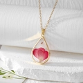 Detail of teardrop resin pendant with pink petals and gold flakes on white stone - Peach Pink Double Heart Flower Leaf