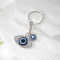 Detailed macro view of Evil Eye keychain with zinc alloy and sparkling pavé crystals - Silver Openwork Eye