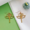Dettaglio degli orecchini a cuore in resina con fiori secchi bianchi e ali dorate lucide - Bacchetta magica con due fiori bianchi e gipsofila