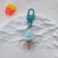 Vue détaillée d'un porte-clés crème glacée bleue avec cône posé sur une assiette en céramique - Cône de Glace Bleu
