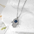 Macroshot van Hamsa Hand-ketting met blauwe Evil Eye en fonkelende kristallen - Zilveren Strass Hamsa Ketting