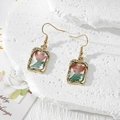 Detail view of handmade resin earrings with red dried flowers on white marble background - Wine Red Flower Green Leaf (Stainless Steel Hook)
