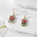 Detail of handmade gold earrings featuring red dried flowers in clear resin pendants - Red Flower Green Leaf (Stainless Steel Hook)