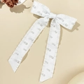 Detail einer eleganten weißen Satinschleife mit Perlen und langen fließenden Bändern - Weiß