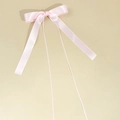 Detalle de un lazo para el pelo de satén rosa claro con cintas largas y diseño dulce - Rosa