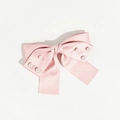 Gros plan d'une barrette nœud en satin rose avec perles blanches sur fond blanc - Rose