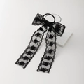 Dettaglio di un elegante elastico in pizzo nero con ricami floreali e nastri lunghi - Nero