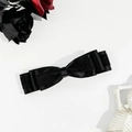 Gothic-Haarspange mit schwarzer Satin- und Spitzenschleife neben dunklen Rosen und Totenkopf - Schwarz