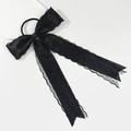 Detalle de un elegante lazo para el pelo de encaje negro de doble capa con cintas largas - Negro