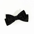 Dettaglio di un elegante fiocco natalizio in velluto nero con texture glitterata dorata - Nero
