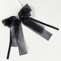 Detalle de un lazo de tul negro con un corazón de diamantes en una base blanca pura - Negro
