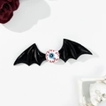Macro shot of Halloween bat wing hair clip with realistic eyeball and gothic rose decor - Black