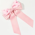 Detalle del lazo de raso rosa con estampados de corazones rojos y cintas largas colgantes - Rosa