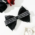 Dettaglio di un fermaglio per capelli a fiocco in pizzo gotico con nastro scritto - Nero