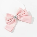Dettaglio del fiocco in raso rosa con decoro a cuore in metallo e fascia elastica - Rosa