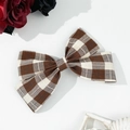 Dettaglio del fermaglio per capelli a quadri marroni con decorazione floreale e vintage - Cachi