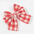 Detailed view of the red and white plaid fabric texture on a large spring hair clip - Red