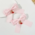 Barrettes à cheveux nœud en satin rose avec pendentifs cœur rouge sur fond minimaliste - Rose