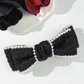 Dettaglio di un fermaglio per capelli a fiocco in jacquard nero con bordi di perle - Nero